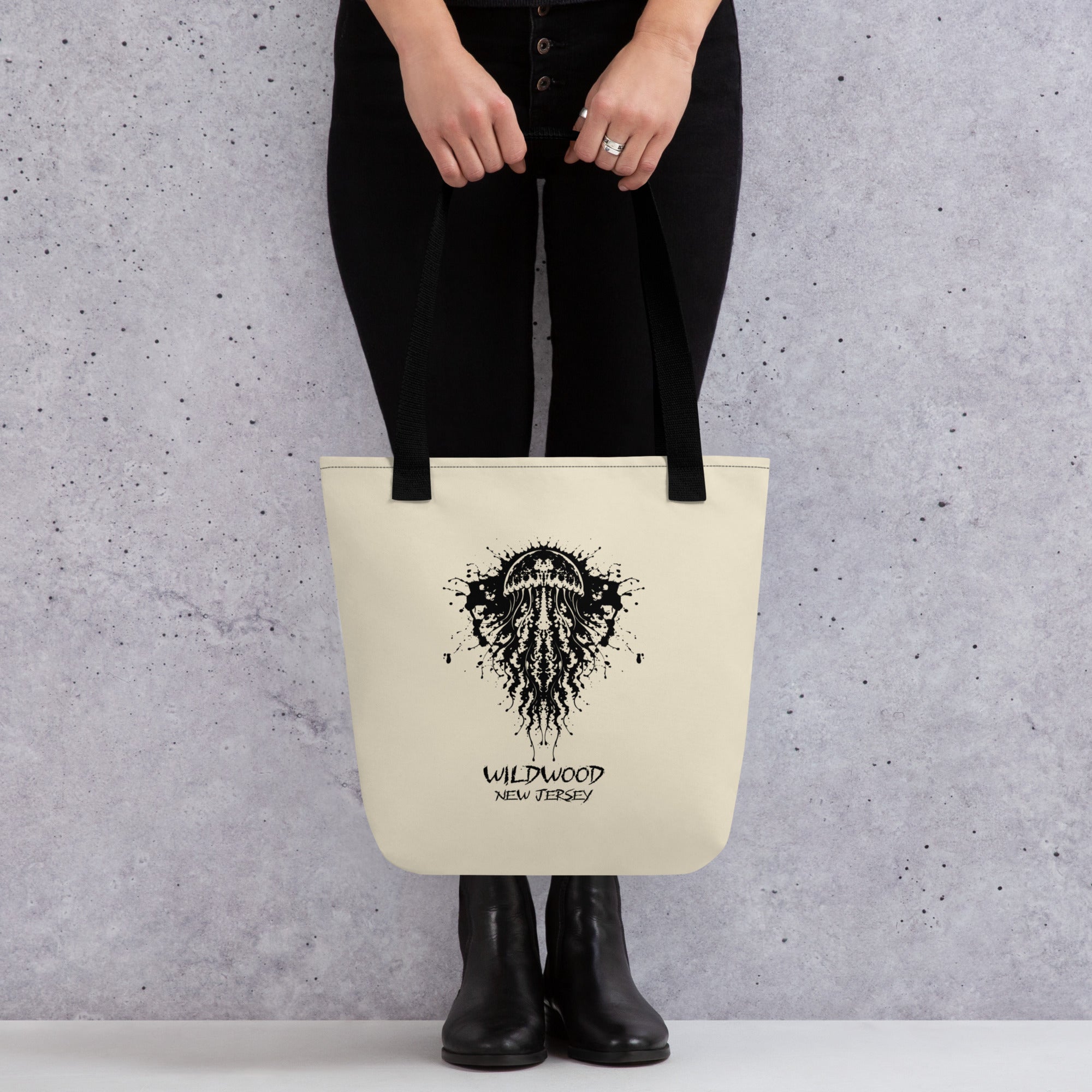 Rorschach Series Jellyfish all-over print canvas tote bag front view held by model featuring black Rorschach ink-blot jellyfish design with "Wildwood New Jersey" text – 17th & Surf