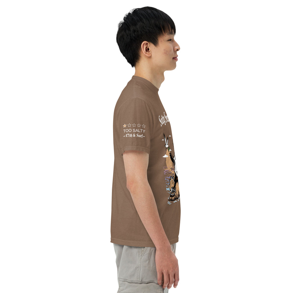 Model wearing "Salty Sea Dawg" front print garment-dyed heavyweight t-shirt in espresso, right angle view featuring full color graphic of a sea lion sprinkling salt on a clam shell with a fish skeleton beneath arched "Salty Sea Dawg" text – 17th & Surf