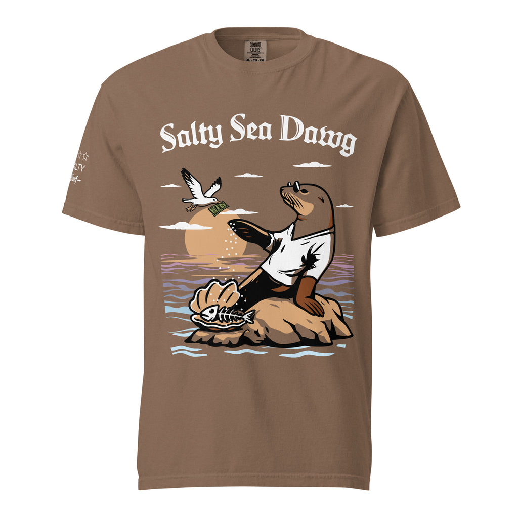 Model wearing "Salty Sea Dawg" front print garment-dyed heavyweight t-shirt in espresso, front view featuring full color graphic of a sea lion sprinkling salt on a clam shell with a fish skeleton beneath arched "Salty Sea Dawg" text and "TOO SALTY" one-star rating with "17th & Surf" wordmark – 17th & Surf