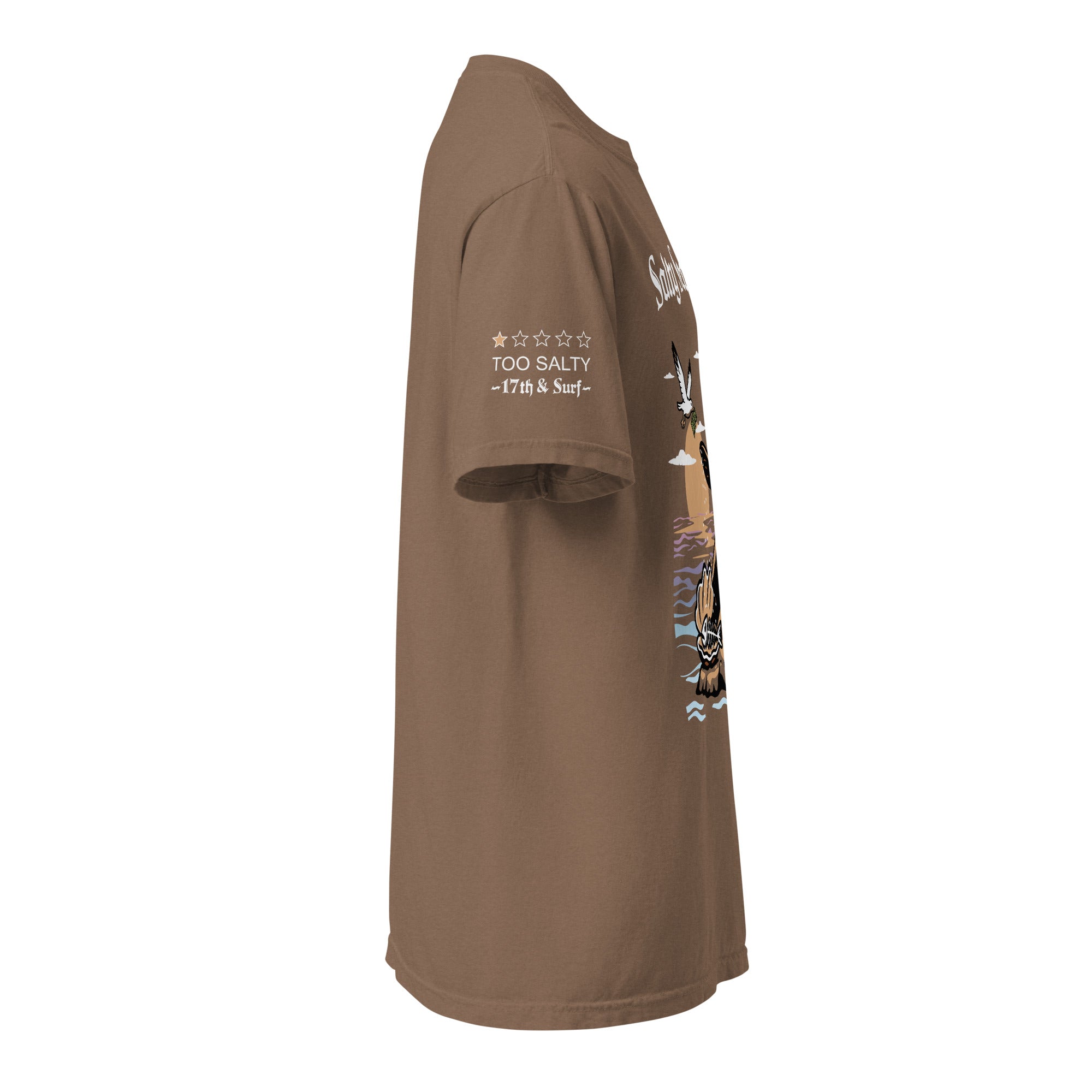 Model wearing "Salty Sea Dawg" front print garment-dyed heavyweight t-shirt in espresso, right side view featuring full color graphic of a sea lion sprinkling salt on a clam shell with a fish skeleton beneath arched "Salty Sea Dawg" text – 17th & Surf