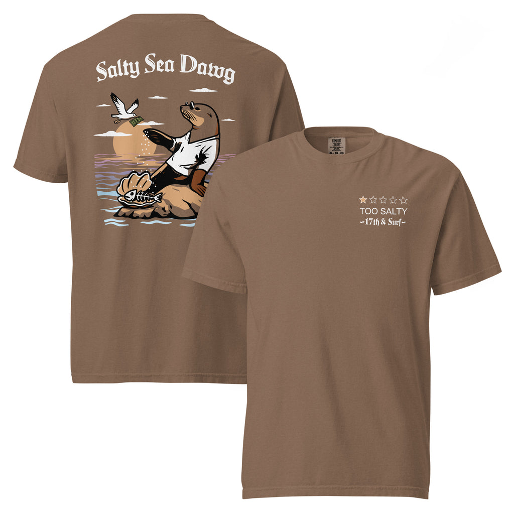 "Salty Sea Dawg" garment-dyed heavyweight t-shirt in espresso, front and back flat lay featuring "TOO SALTY" one-star rating and "17th & Surf" wordmark on front and full color graphic on back of a sea lion sprinkling salt on a clam shell with a fish skeleton beneath arched "Salty Sea Dawg" text – 17th & Surf