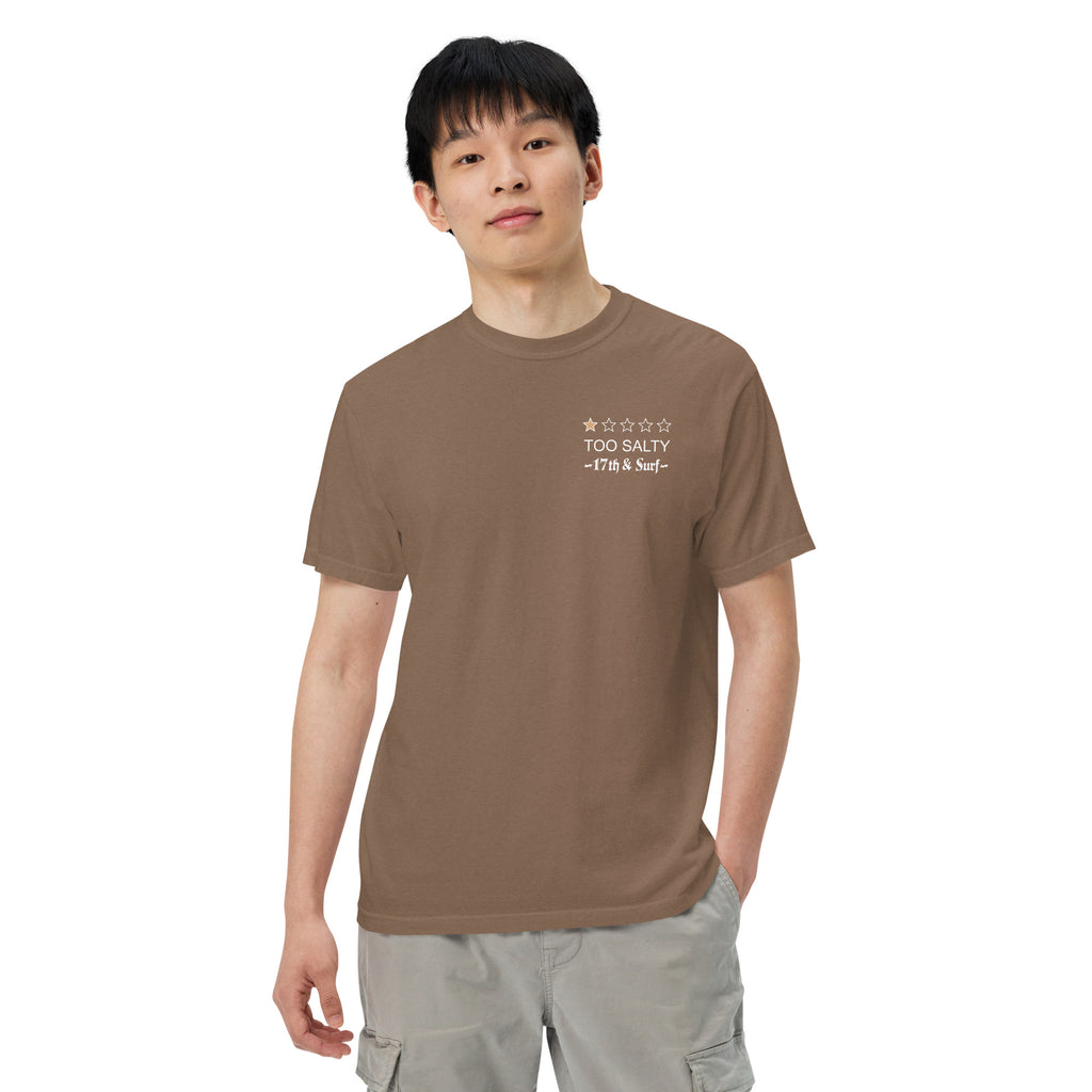 Model wearing "Salty Sea Dawg" garment-dyed heavyweight t-shirt in espresso with "TOO SALTY" one-star rating and "17th & Surf" chest logo, front angle view – 17th & Surf