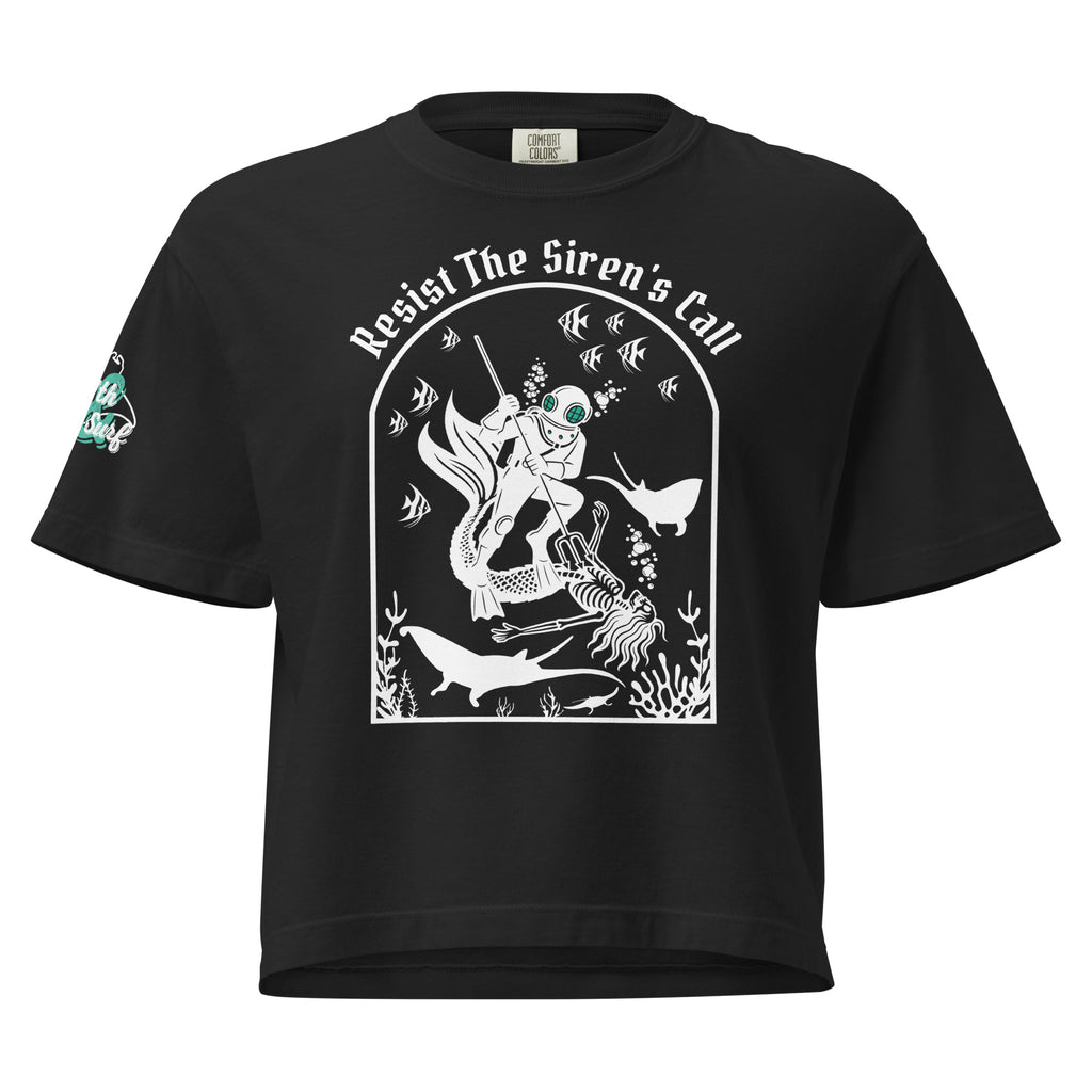 "Resist The Siren's Call" women's heavyweight boxy t-shirt front view in black featuring white-print arched graphic of a deep-sea diver spearing a mermaid skeleton surrounded by tropical fish and manta rays – 17th & Surf