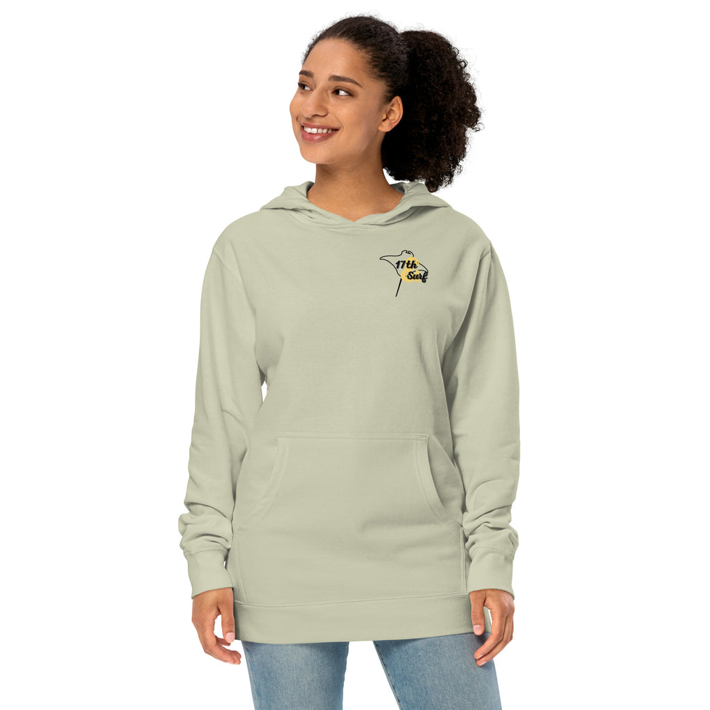 Model wearing "Resist The Siren's Call" garment-dyed heavyweight hoodie in dusty sage with black and yellow "17th & Surf" manta ray chest logo, front angle view – 17th & Surf
