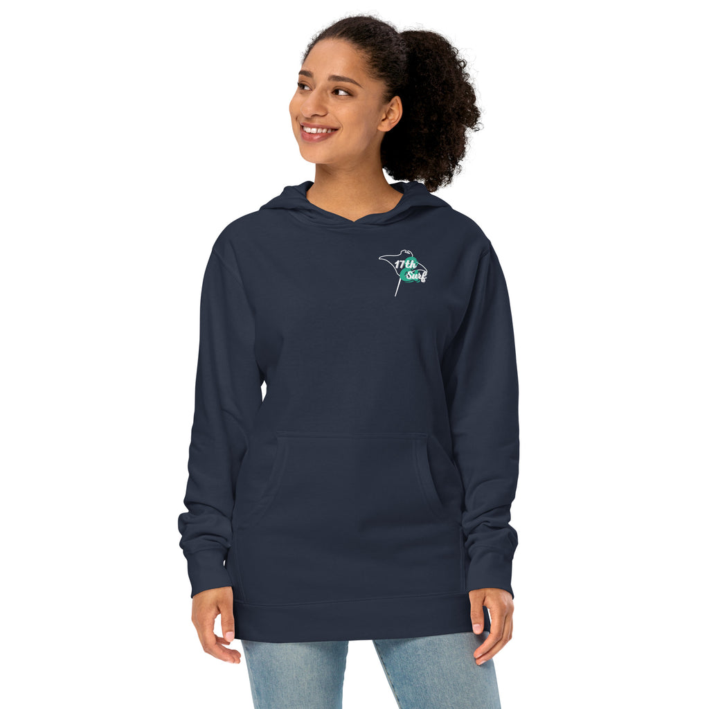 Model wearing "Resist The Siren's Call" garment-dyed heavyweight hoodie in classic navy with white and teal "17th & Surf" manta ray chest logo, front angle view – 17th & Surf