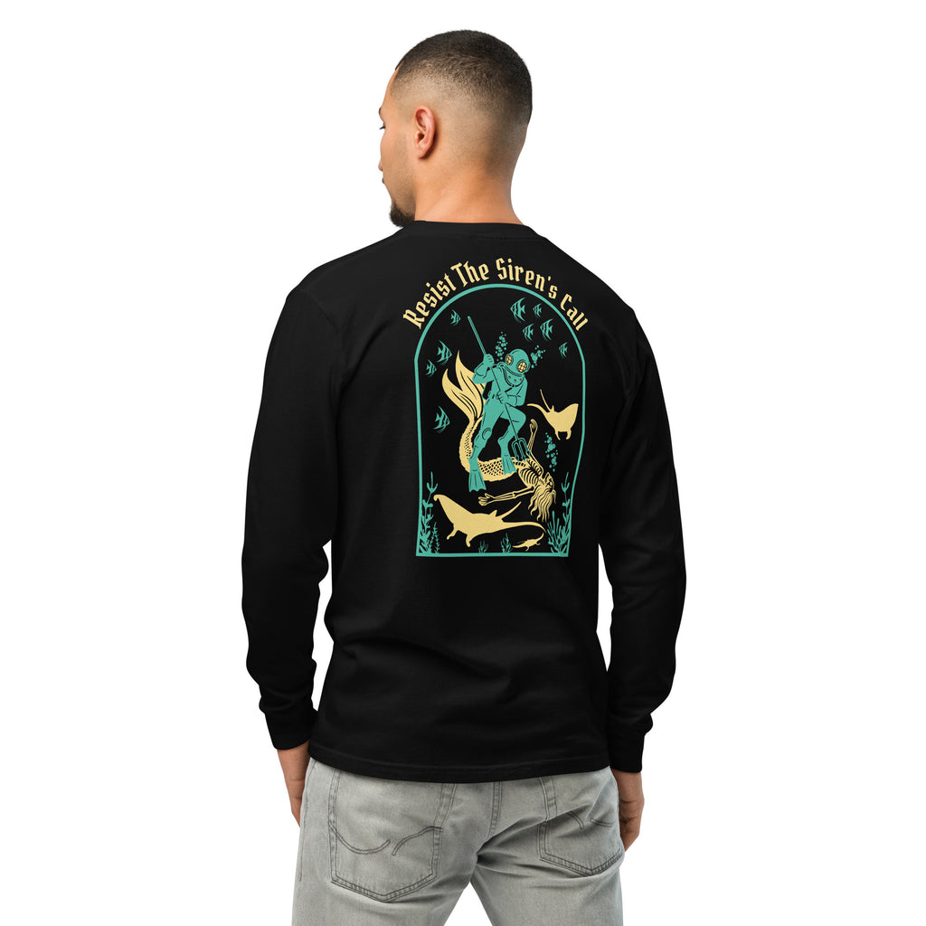 Model wearing "Resist The Siren's Call" garment-dyed heavyweight long sleeve shirt in black, back view featuring teal and gold arched graphic of a deep-sea diver spearing a mermaid skeleton surrounded by fish and manta rays – 17th & Surf