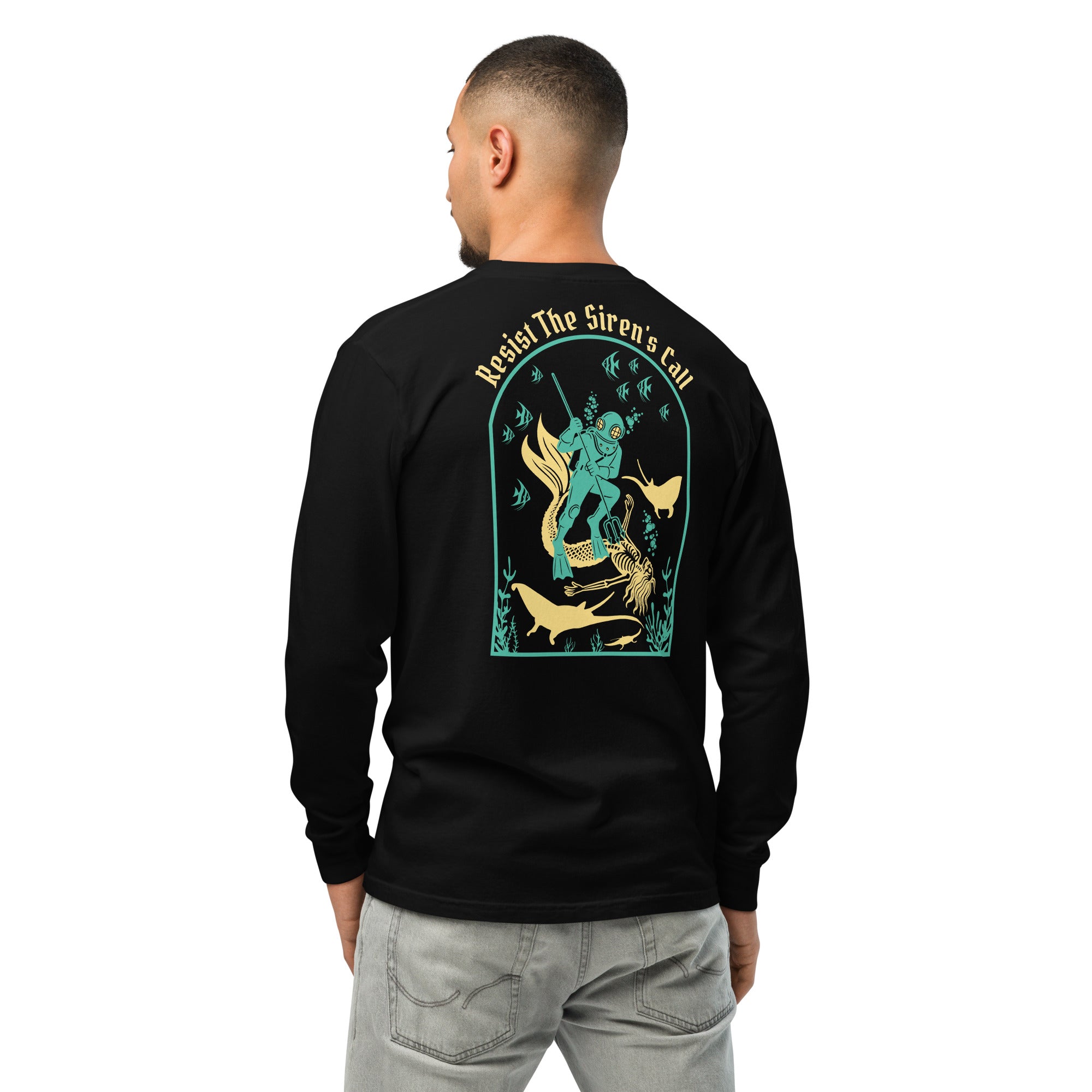 Model wearing "Resist The Siren's Call" garment-dyed heavyweight long sleeve shirt in black, back view featuring teal and gold arched graphic of a deep-sea diver spearing a mermaid skeleton surrounded by fish and manta rays – 17th & Surf
