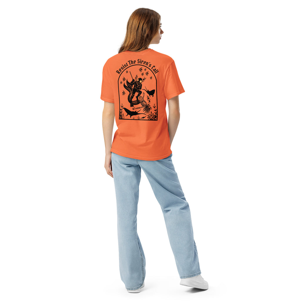Model wearing "Resist The Siren's Call" black print garment-dyed heavyweight t-shirt in burnt orange, back angle view featuring black arched graphic of a deep-sea diver spearing a mermaid skeleton surrounded by fish and manta rays – 17th & Surf