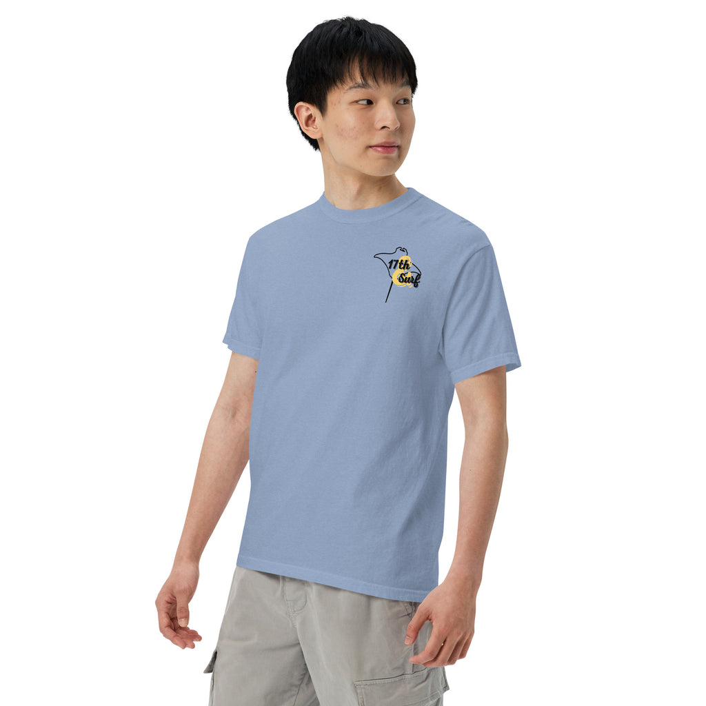 Model wearing "Resist The Siren's Call" black print garment-dyed heavyweight t-shirt in washed denim blue with black and yellow "17th & Surf" manta ray chest logo, front angle view – 17th & Surf