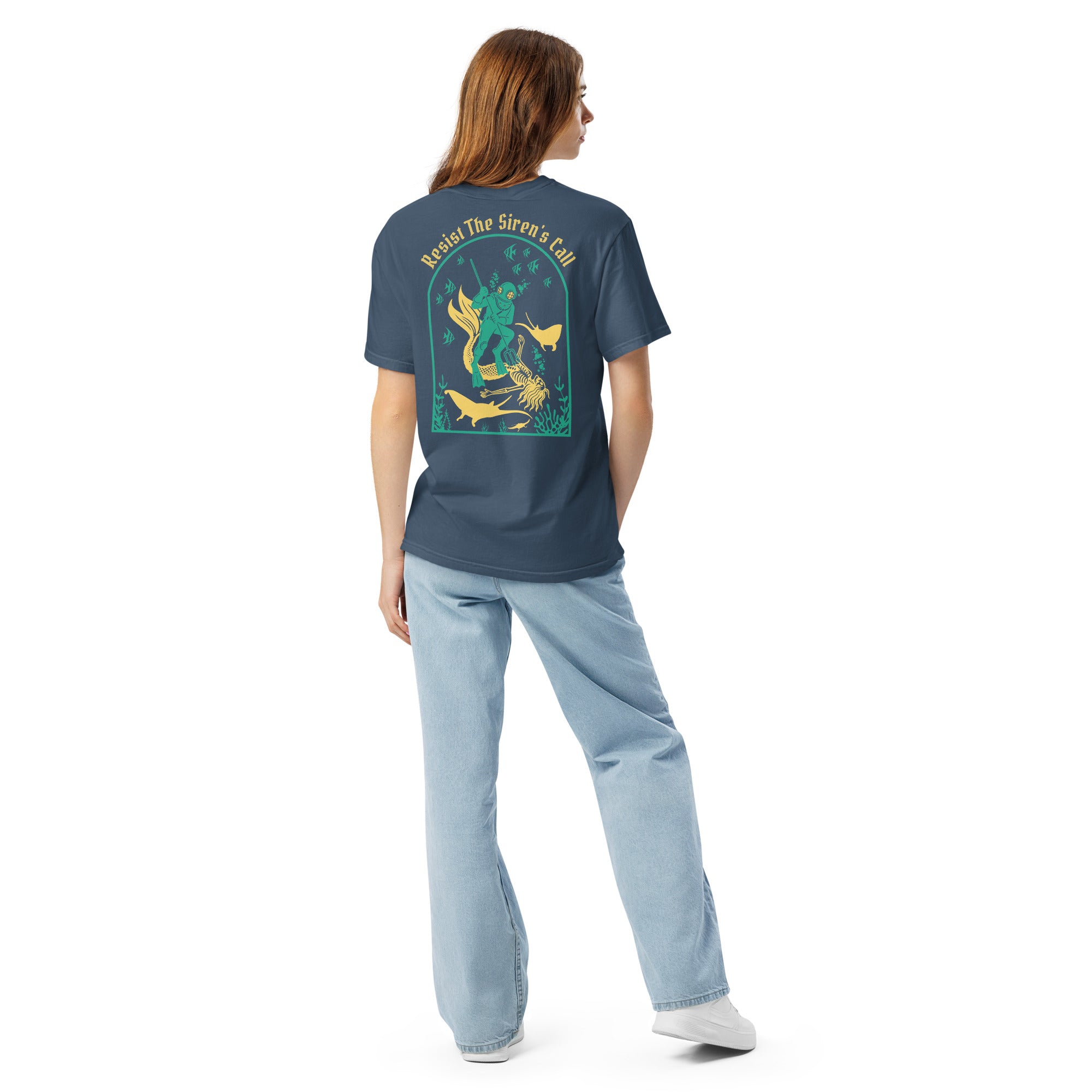 Model wearing "Resist The Siren's Call" color print garment-dyed heavyweight t-shirt in midnight, back view featuring teal and yellow arched graphic of a deep-sea diver spearing a mermaid skeleton surrounded by fish and manta rays – 17th & Surf