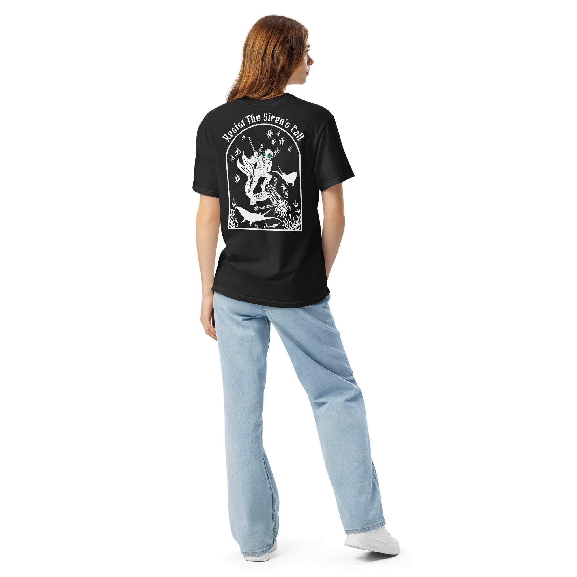 Model wearing "Resist The Siren's Call" white print garment-dyed heavyweight t-shirt in black, back angle view featuring white arched graphic of a deep-sea diver spearing a mermaid skeleton surrounded by fish and manta rays – 17th & Surf