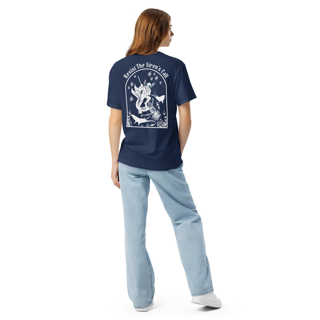 Model wearing "Resist The Siren's Call" white print garment-dyed heavyweight t-shirt in true navy, back angle view featuring white arched graphic of a deep-sea diver spearing a mermaid skeleton surrounded by fish and manta rays – 17th & Surf