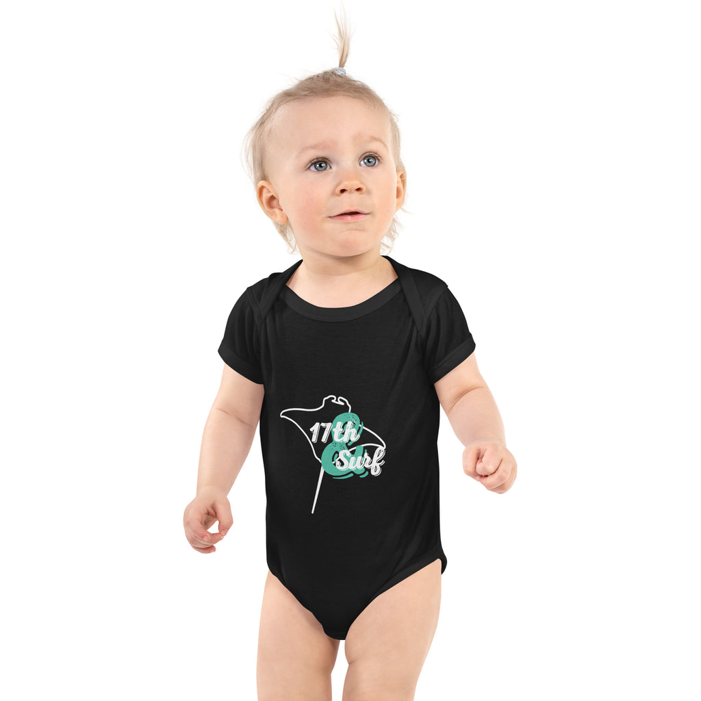 Baby wearing a black short sleeve onesie with a teal and white stingray-shaped "17th & Surf" logo – 17th & Surf