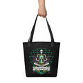"Take Time To Decompress" black tote bag, held by model showing the front panel featuring a meditating skeleton holding a glowing hourglass with a tiny silhouette inside, framed by a green geometric pyramid pattern with purple coral accents and gold ammonite shells, above a "Take Time To Decompress" banner – 17th & Surf