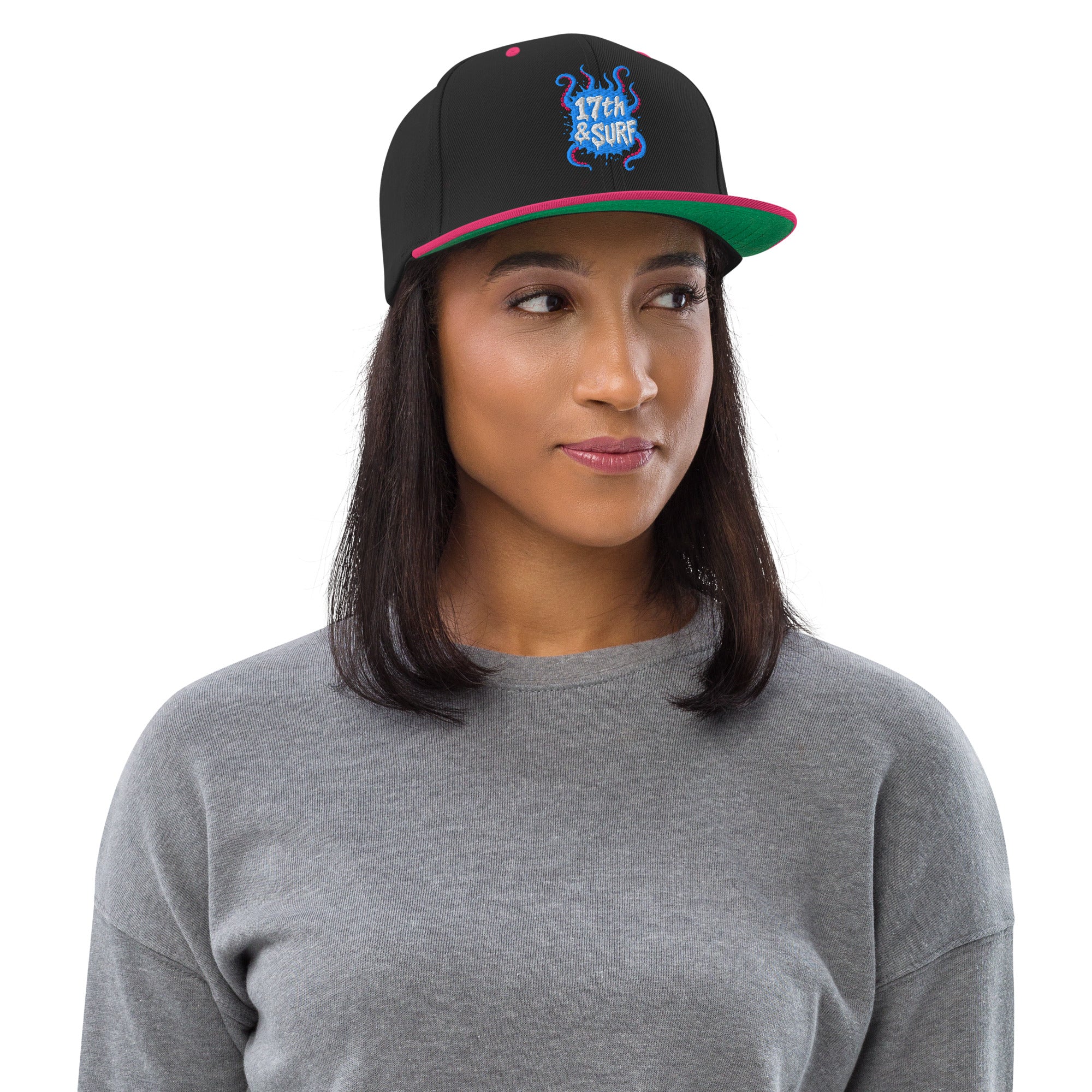 Model wearing the 17th & Surf Tentacles snapback hat at an angle, showing the green and pink underside of the brim and the tentacle-themed "17th & Surf" logo – 17th & Surf