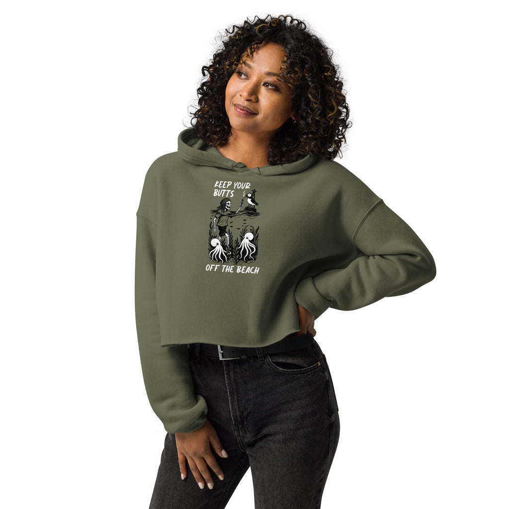 Female Model wearing women’s military green cropped hoodie with smoking skeleton and puffin beach graphic
