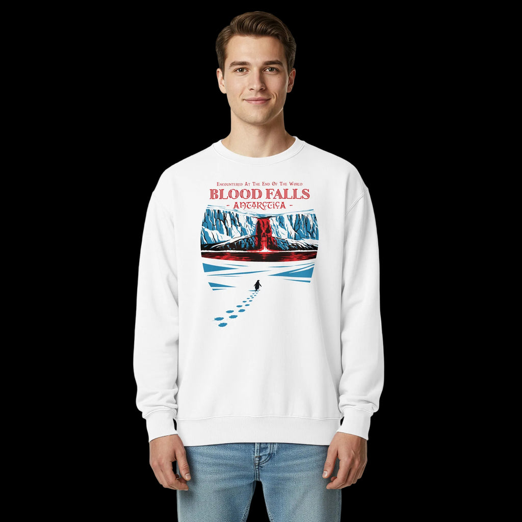 Man wearing white 17th & Surf Blood Falls Antarctica sweatshirt featuring penguin walking toward red waterfall beneath icy cliffs