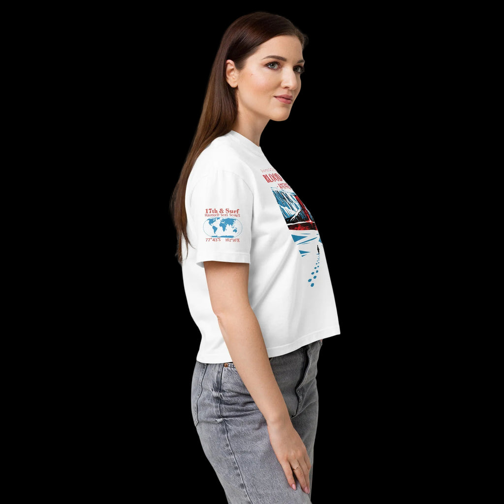 Side profile of model in white women’s heavyweight boxy tee featuring Haunted Seas sleeve graphic with coordinates 77°43'S 162°16'E